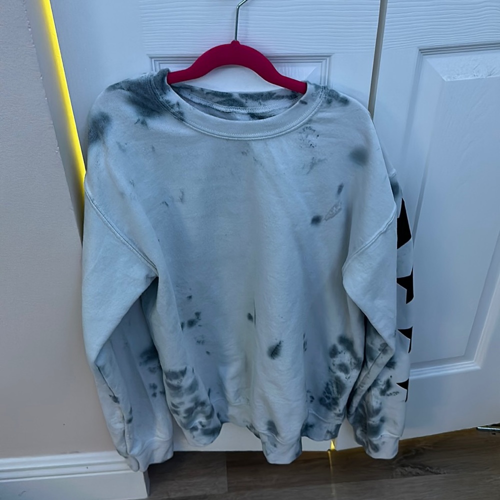 Blue and black tie dye hoodie with black stars on the sleeve from a boutique